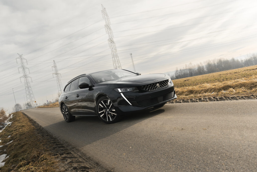 Przód nowoczesnego samochodu kombi na drodze przy polu, fotograf Skawina, sesja zdjęciowa.